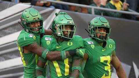 Oregon's Bryan Addison, left, Daewood Davis and Johnny Johnson III celebrate a fourth-quarter interception that Davis ran back for a touchdown against Nevada in an NCAA college football game Saturday, Sept. 7, 2019, in Eugene, Oregon.