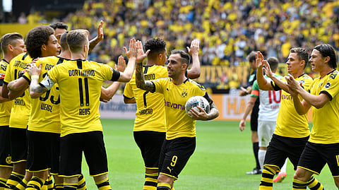 This photo, taken Aug.17, 2019, shows Dortmund's Paco Alcacer holding the ball as he celebrates after scoring his side's first goal during the German Bundesliga soccer match between Borussia Dortmund and FC Augsburg at the Signal Iduna Park stadium in Dortmund, Germany.