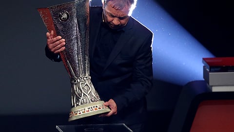 Former Poland midfielder Andrzej Buncol places the Europa League trophy during the UEFA group stage draw at the Grimaldi Forum, in Monaco, Friday, Aug. 30, 2019.