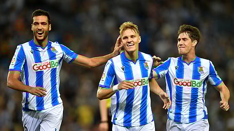 In this Sept. 26, 2019 file photo, Real Sociedad's Martin Odegaard, center, celebrates with teammates Mikel Merino and Aritz Elustondo, right, after a goal of their team during the Spanish La Liga soccer match between Real Sociedad and Alaves at Reale Arena stadium, in San Sebastian, northern Spain.