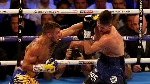 Vasiliy Lomachenko, left, and Luke Campbell fight during the WBC, WBO, WBA & Ring Magazine World Lightweight Championship contest at the O2 Arena, London on Saturday, Aug. 31, 2019. (Steven Paston/PA via AP)