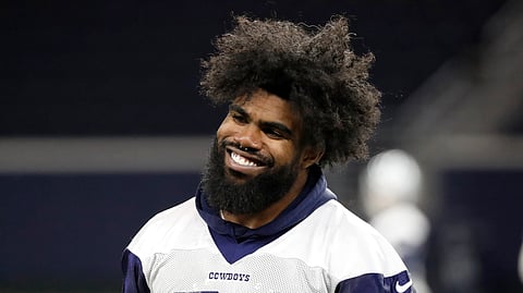In this June 12, 2019, file photo, Dallas Cowboys running back Ezekiel Elliott smiles as he walks off the field after participating in drills at the team's NFL football training facility in Frisco, Texas.