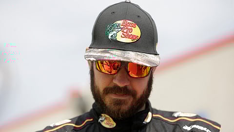 Martin Truex Jr. pauses to sign an autograph for a fan during practice for Sunday's NASCAR Cup Series auto race at Charlotte Motor Speedway in Concord, N.C., Saturday, Sept. 28, 2019. (AP Photo/Gerry Broome)