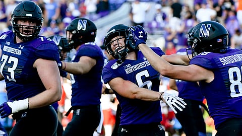 Northwestern running back Drake Anderson, center, celebrates with Northwestern offensive lineman Gunnar Vogel (73) and wide receiver Bennett Skowronek (88) after Anderson scored a touchdown against UNLV during the second half of an NCAA college football game, Saturday, Sept. 14, 2019, in Evanston, Ill.