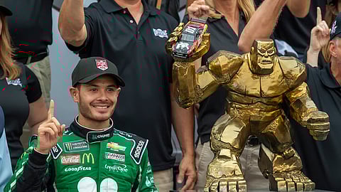 Kyle Larson stands next to the trophy after winning the NASCAR Cup Series auto race Sunday, Oct. 6, 2019, at Dover International Speedway in Dover, Del. (AP Photo/Jason Minto)