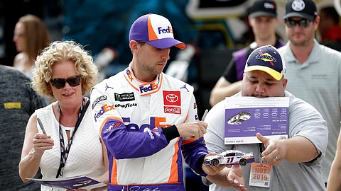 Denny Hamlin signs autographs during practice for Sunday's NASCAR Cup Series auto race at Charlotte Motor Speedway in Concord, N.C., Saturday, Sept. 28, 2019. (AP Photo/Gerry Broome)