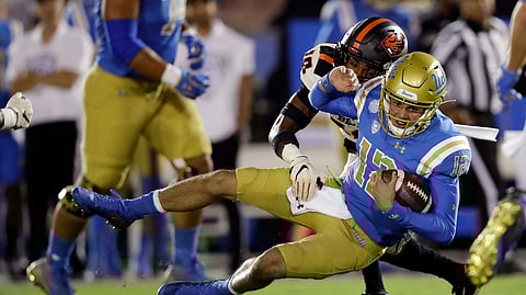 UCLA quarterback Austin Burton (12) is tackled y Oregon State defensive back Omar Hicks-Onu, top, during the first half of an NCAA college football game Saturday, Oct. 5, 2019, in Pasadena, California.