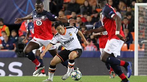 Valencia's Lee Kang-in, center, vies for the ball with Lille's Boubakary Soumare, left, during the Champions League group H soccer match between Valencia and Lille at the Mestalla stadium in Valencia, Spain, Tuesday, Nov. 5, 2019.