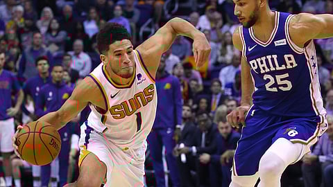 Phoenix Suns guard Devin Booker (1) drives past Philadelphia 76ers guard Ben Simmons (25) during the second half of an NBA basketball game, Monday, Nov. 4, 2019, in Phoenix.