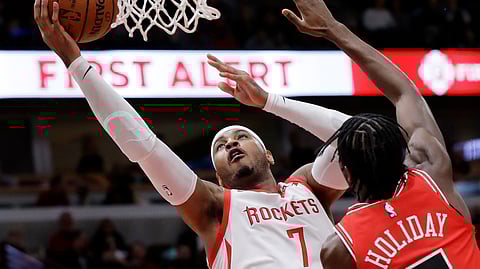 In this Nov. 3, 2018, file photo, Houston Rockets forward Carmelo Anthony, left, drives to the basket against Chicago Bulls forward Justin Holiday during the first half of an NBA basketball game in Chicago. Anthony is returning to the NBA with the Portland Trail Blazers.