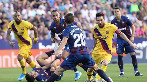 Barcelona's Lionel Messi controls the ball past Levante's Jorge Miramon during the Spanish La Liga soccer match in Valencia, Spain, Nov.2 , 2019.