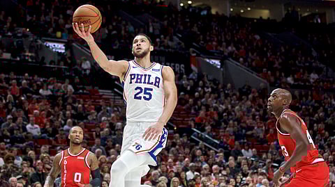 Philadelphia 76ers guard Ben Simmons, center, shoots between Portland Trail Blazers guard Damian Lillard, left, and forward Anthony Tolliver, right, during the first half of an NBA basketball game in Portland, Ore., Saturday, Nov. 2, 2019.