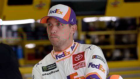FILE - In this Sept. 28, 2019, file photo, Denny Hamlin climbs into is car to practice for the NASCAR Cup Series auto race at Charlotte Motor Speedway in Concord, N.C. Hamlin thought he was the favorite to win NASCAR’s championship but now finds himself in danger of not even making it to the title round. Chase Elliott is fairly certain he’s backed himself into such a hole that his only chance at a championship is by winning Sunday’s penultimate race of the season. (AP Photo/Gerry Broome, File)