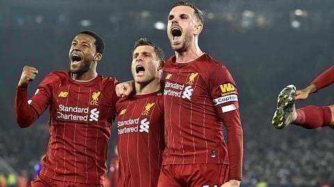 Liverpool's James Milner, second left, celebrates with his teammate Liverpool's Georginio Wijnaldum, left, and Liverpool's Jordan Henderson after scoring his side's second goal during the English Premier League soccer match between Leicester City and Liverpool at the King Power Stadium in Leicester, England, Thursday, Dec. 26, 2019.