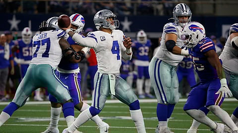 Dallas Cowboys quarterback Dak Prescott (4) throws a pass under pressure from Buffalo Bills defensive end Jerry Hughes (55) in the second half of an NFL football game in Arlington, Texas, Thursday, Nov. 28, 2019.