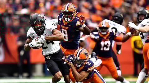 Wake Forest wide receiver Donavon Greene, left, is tackled by Syracuse defensive back Christopher Fredrick after a reception during the first half of an NCAA college football game in Syracuse, N.Y., Saturday, Nov. 30, 2019.
