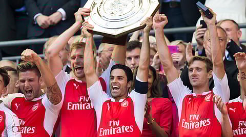 FILE - In this Sunday Aug. 2, 2015 file photo, Arsenal's Mikel Arteta, centre, lifts the Community Shield trophy after his team beat Chelsea 1-0 in the English Community Shield soccer match at Wembley Stadium, London. Arsenal hired Mikel Arteta as manager on Friday, Dec. 20, 2019, hoping its former midfielder can turn around the fortunes of the ailing London club after spending more than three years learning the coaching ropes as assistant to Pep Guardiola at English champion Manchester City. (AP Photo/Jon Super, file)