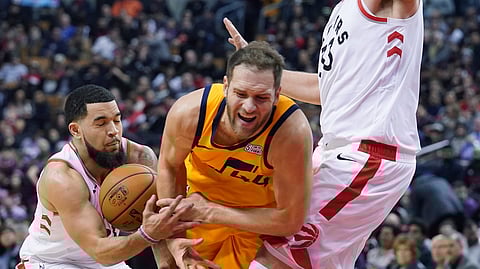 Utah Jazz's Bojan Bogdanovic (44) is fouled by Toronto Raptors' Fred VanVleet (23) during first half NBA basketball action in Toronto, Sunday, Dec. 1, 2019. (Hans Deryk/The Canadian Press via AP)