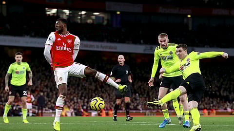 Sheffield United's John Fleck, right, scores his sides first goal past Arsenal's Ainsley Maitland-Niles during the English Premier League soccer match between Arsenal and Sheffield United at the Emirates Stadium, London, Saturday, Jan. 18, 2020.