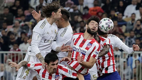 Atletico Madrid's players and Real Madrid's players jump for the ball during the Spanish Super Cup Final soccer match between Real Madrid and Atletico Madrid at King Abdullah stadium in Jiddah, Saudi Arabia, Sunday, Jan. 12, 2020.