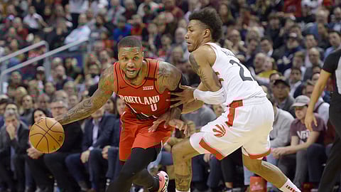 Portland Trail Blazers guard Damian Lillard (0) is defended by Toronto Raptors guard Patrick McCaw (22) during the second half of an NBA basketball game Tuesday, Jan. 7, 2020, in Toronto.