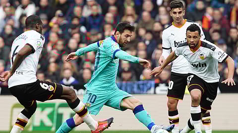 Barcelona's Lionel Messi, center, tries to dribble past Valencia's Geoffrey Kondogbia, left, and Valencia's Francis Coquelin during the Spanish La Liga soccer match between Valencia and Barcelona at the Mestalla Stadium in Valencia, Spain, Saturday, Jan. 25, 2020.