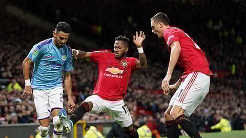 Manchester United's Fred, centre tackles Manchester City's Riyad Mahrez, left, for the ball during the English League Cup semifinal first leg soccer match between Manchester United and Manchester City and at Old Trafford, Manchester, England, Tuesday, Jan. 7, 2020.