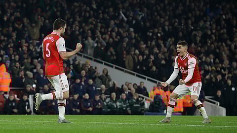 Arsenal's Sokratis Papastathopoulos, left, celebrates with teammate Lucas Torreira after scoring their side's second goal during the English Premier League soccer match between Arsenal and Manchester United at the Emirates Stadium in London, Wednesday, Jan. 1, 2020.