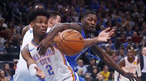 Oklahoma City Thunder guard Shai Gilgeous-Alexander (2) and Dallas Mavericks forward Dorian Finney-Smith, right, reach for the ball during the first half of an NBA basketball game Tuesday, Dec. 31, 2019, in Oklahoma City.