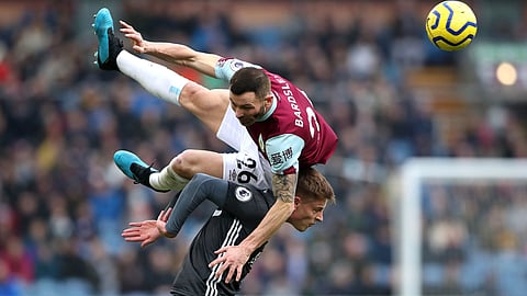 Leicester City's Harvey Barnes vies for the ball with Burnley's Phil Bardsley, in air, during the English Premier League soccer match between Burnley and Leicester City at Turf Moor, in Burnley, England, Sunday, Jan. 19, 2020.
