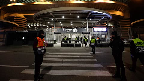 Stewards stand at a gate of the San Siro stadium in Milan, Italy, Thursday, Feb. 27, 2020. Ludogorets is playing Italian club Inter Milan in a Europa League soccer match on Thursday that is scheduled to go ahead in an empty stadium due to the coronavirus outbreak. (AP Photo/Luca Bruno)