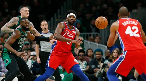Philadelphia 76ers' Joel Embiid (21) passes to Al Horford (42) as Boston Celtics' Jaylen Brown (7) and Daniel Theis, back left, defend during the first half of an NBA basketball game in Boston, Saturday, Feb. 1, 2020.