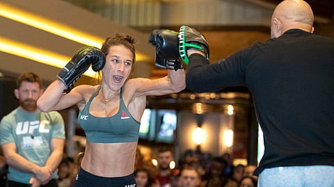 Former UFC women's strawweight champion Joanna Jedrzejczyk, of Poland, works on her timing with striking coach Mike Rodriquez during open workouts in Las Vegas on Wednesday, March 4, 2020, for her Saturday bout against Zhang Weili. (Steve Marcus/Las Vegas Sun via AP)