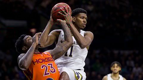 Notre Dame's Juwan Durham (11) grabs a rebound over Virginia Tech's Tyrece Radford (23) during the first half of an NCAA college basketball game Saturday, March 7, 2020, in South Bend, Ind. (AP Photo/Robert Franklin)