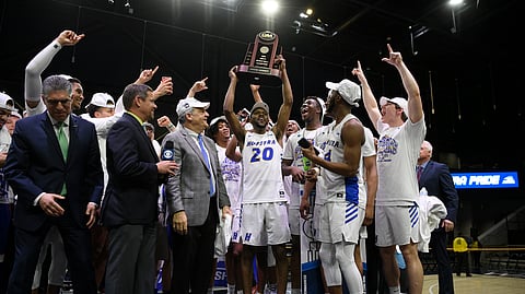 Hofstra guard Jalen Ray (20) and others raise the trophy after defeating Northeastern in an NCAA college basketball game for the championship of the Colonial Athletic Association men's tournament Tuesday, March 10, 2020, in Washington. Hofstra won 70-61. (AP Photo/Nick Wass)