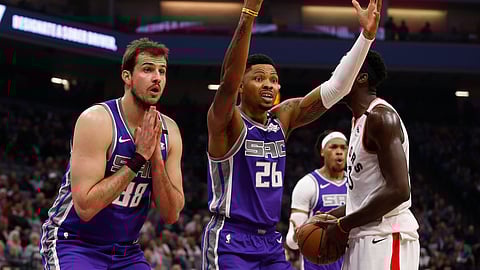 Sacramento Kings' Nemanja Bjelica, left, and Kent Bazemore, center, react after Bazemore was called for fouling Toronto Raptors forward Pascal Siakam, right, during the first quarter of an NBA basketball game in Sacramento, Calif., Sunday, March 8, 2020. (AP Photo/Rich Pedroncelli)