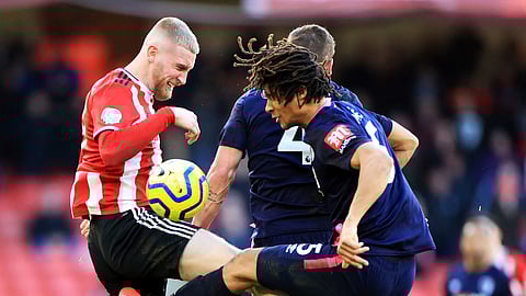 Sheffield United's Oliver McBurnie, left, and Bournemouth's Nathan Ake battle for the ball during the English Premier League soccer match at Bramall Lane, Sheffield, England, Sunday Feb. 9, 2020.