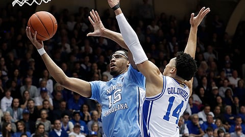 North Carolina forward Garrison Brooks (15) drives to the basket whiule Duke guard Jordan Goldwire (14) defends during the first half of an NCAA college basketball game in Durham, N.C., Saturday, March 7, 2020. (AP Photo/Gerry Broome)