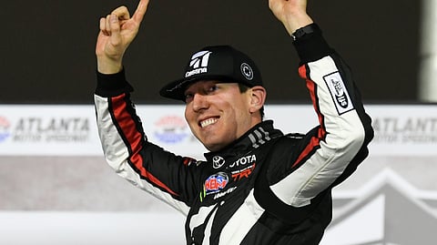 In this Feb. 23, 2019, file photo ,Kyle Busch celebrates after winning the NASCAR Truck Series auto race at Atlanta Motor Speedway in Hampton, Ga. Busch says, “Bring it on.” Chase Elliott and Kyle Larson are the latest topflight drivers to accept the challenge of Kevin Harvick, who has offered half of a $100,000 bounty to any Cup Series driver who can beat the versatile Busch in a Truck Series race this year.
