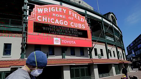 In this April 16, 2020, file photo, Wrigley Field's marquee displays Lakeview Pantry volunteer information in Chicago. With no games being played, recent sports headlines have centered around hopes and dreams — namely, the uncharted path leagues and teams must navigate to return to competition in the wake of the pandemic.