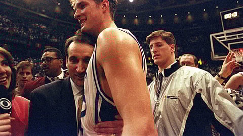 In this March 28, 1992, file photo, Duke University basketball head coach Mike Krzyzewski hugs his star center Christian Laettner after Duke defeated Kentucky in overtime 104-103 to win NCAA East Regional Final in Philadelphia. Duke would go on to become the first team in 19 years to repeat as NCAA champion with a 71-51 victory over Michigan’s Fab Five freshmen.