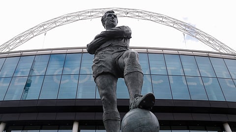 The statue of the late England player Bobby Moore outside Wembley Stadium in London, Tuesday, March 17, 2020. UEFA has formally proposed postponing the 2020 European Championship for one year because of the coronavirus outbreak. The Norwegian soccer association says the new tournament dates will be June 11 to July 11. (AP Photo/Alastair Grant)