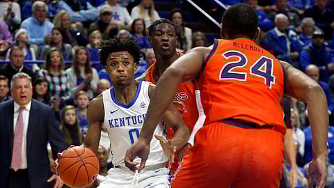 Kentucky's Ashton Hagans, left, looks for an opening against Auburn's Anfernee McLemore (24) during the first half of an NCAA college basketball game in Lexington, Ky., Saturday, Feb. 29, 2020.