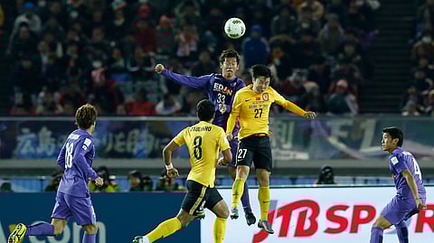 In this Dec. 20, 2015, file photo, Guangzhou Evergrande FC's Zheng Long, right, and Sanfrecce Hiroshima's Tsukasa Shiotani, left, leap to head the ball during their match for the third place at the FIFA Club World Cup soccer tournament in Yokohama, near Tokyo. The Chinese Super League is reportedly set to kick off in the last week of June 2020, two weeks after lower-tier leagues are scheduled to begin in the wake of the coronavirus pandemic that has shut down sports globally.