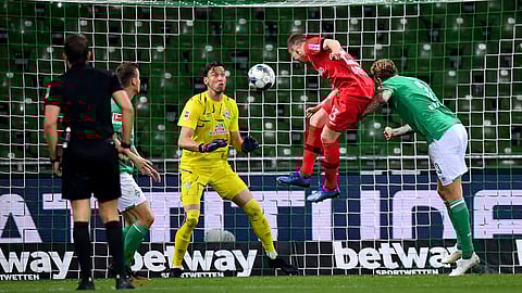 Mitchell Weiser, center, of Leverkusen scores his team's 3rd goal during the German Bundesliga soccer match between Werder Bremen and Bayer Leverkusen 04 in Bremen, Germany, Monday, May 18, 2020.