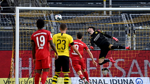 Dortmund's goalkeeper Roman Buerki, right, fails to stop a shot by Munich's Joshua Kimmich during the German Bundesliga soccer match between Borussia Dortmund and FC Bayern Munich in Dortmund, Germany, Tuesday, May 26, 2020.