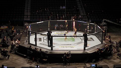 Michelle Waterson, center left, and Carla Esparza battle without spectators during a UFC 249 mixed martial arts bout, Saturday, May 9, 2020, in Jacksonville, Fla. (AP Photo/John Raoux)