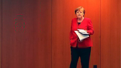 German Chancellor Angela Merkel waits for the beginning of a press conference in Berlin, Germany, Wednesday, May 6, 2020 after an online meeting of Merkel and the German state governors on the loosening of the restrictions to reduce the spread of the new coronavirus.