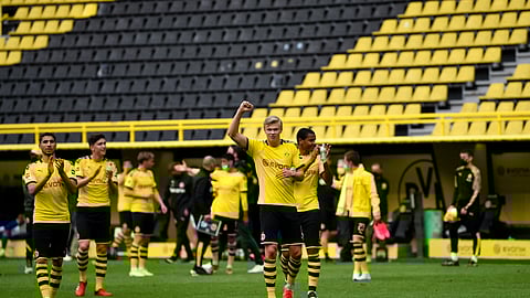 Dortmund's Erling Haaland, center, and his teammates celebrate at the end of the German Bundesliga soccer match between Borussia Dortmund and Schalke 04 in Dortmund, Germany, Saturday, May 16, 2020. The German Bundesliga becomes the world's first major soccer league to resume after a two-month suspension because of the coronavirus pandemic. Dortmund won 4-0. (AP Photo/Martin Meissner, Pool)