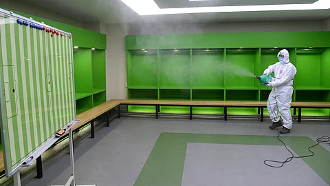 A worker wearing protective gear disinfects as a precaution against the coronavirus at a team dressing room at the Jeonju World Cup Stadium in Jeonju, South Korea, Thursday, May 7, 2020. South Korea's soccer league will kick off the season Friday, three days after the first pitch was thrown in baseball, in yet another sign that life in the country is starting to return to normal after strenuous efforts to contain the coronavirus. (Kim Orel/Newsis via AP)